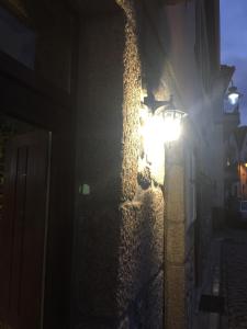 a street light on the side of a building at night at Casas do Terreiro in Seia