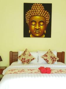 a bed with a picture of a gold head on it at Amed Kunara Guest House in Amed