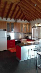 cocina con armarios rojos y nevera blanca en Casa do Galante, en Nordeste