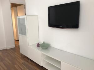 Apartamento Nuria في تاراغونا: خزانة بيضاء مع تلفزيون على الحائط