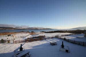 two benches in the snow next to a fence at Arle Lodge in Tobermory