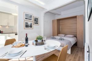 a white room with a bed and a table and chairs at LE ROSSETTI B. - modern, long balcony, old town Nice in Nice