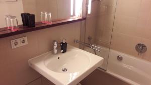 a bathroom with a white sink and a shower at Apartment MUSIKVIERTEL in Leipzig +12 photos