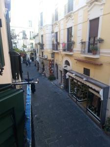 a narrow street with buildings and a dog walking down it at B&B Lumasa in Vietri sul Mare