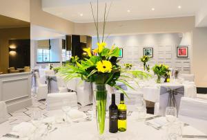 a table with yellow flowers in a vase on it at Malmaison Hotel Leeds in Leeds
