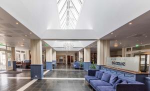 un vestíbulo con sofás azules en un edificio en Kviknes Hotel, en Balestrand