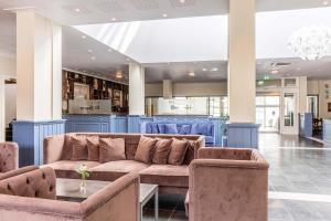 a lobby with a couch and blue chairs at Kviknes Hotel in Balestrand