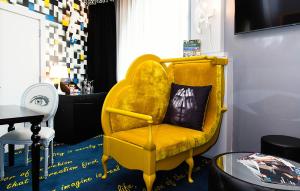 a yellow chair with a black pillow in a room at Malmaison Hotel Leeds in Leeds