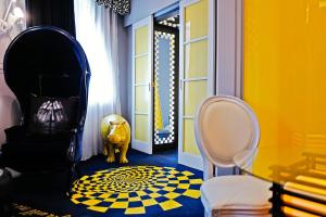 a hallway with a yellow and blue room with a chair at Malmaison Hotel Leeds in Leeds