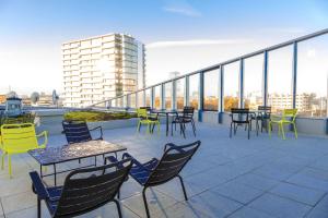 a patio with tables and chairs on a roof at Appart'hôtel Odalys City - Paris XVII in Paris