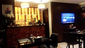 a restaurant with a bar with a table and a television at Syama Suite Sukhumvit 20 in Bangkok