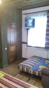 タターリウにあるMaghura Gostinnii Dvirのベッドルーム1室(ベッド1台、壁掛けテレビ付)