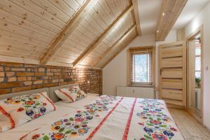 カルパチにあるApartamenty Pod Skoczniąの木製の天井が特徴のベッドルーム1室(大型ベッド1台付)