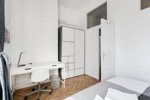 Habitación blanca con escritorio y cama en Synagogue view residence en Budapest