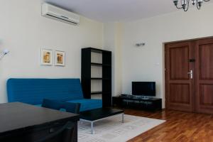 a living room with a blue couch and a tv at Apartamenty „Lofty w piecowni” in Włocławek