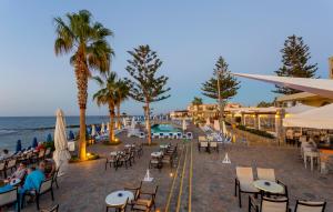 マリアにあるDessole Malia Beach - All Inclusiveの海の景色を望むビーチ(テーブル、椅子付)