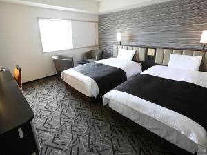 um quarto de hotel com duas camas e uma janela em APA Hotel & Resort Sapporo em Sapporo