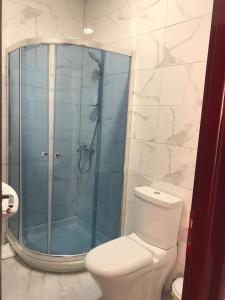 a bathroom with a toilet and a glass shower at Kompleksi Kenaqesia in Barç