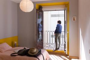 
a man standing in front of a door on a bed at Sungate ONE in Madrid
