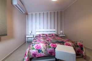 ポルト・エンペードクレにあるB&B Villa Marikaのベッドルーム(大型ベッド1台、白い椅子付)