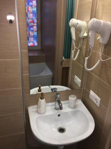 アルハンゲリスクにあるSerafima Hotelのバスルーム(白い洗面台、鏡付)