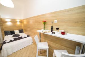 リヴィウにあるMini Economy apartments- Filatova 10のベッドルーム1室(ベッド1台、花瓶付きのデスク付)