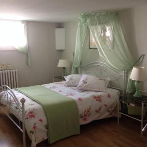 una camera con un letto e un piumone verde e bianco di Agora Mijo Chambre d'Hôtes a Nantes