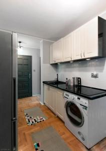 kuchnia z pralką i lodówką w obiekcie ClickTheFlat Hoża Street Apart Rooms w Warszawie
