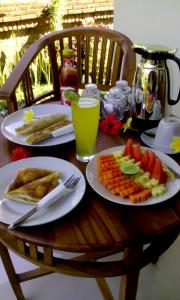 a wooden table with plates of food on it at ThreeWin Homestay in Ubud