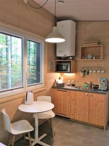 eine Küche mit einem Tisch, einem Tisch und Stühlen in der Unterkunft Les Cabanes du Mont in Coeuve