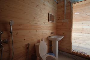 a wooden bathroom with a toilet and a sink at Agonda Paradise in Agonda +37 photos