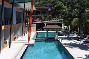 - une piscine avec un parasol à côté d'un bâtiment dans l'établissement Phi Phi Anita Resort, sur les Îles Phi Phi