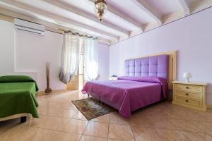 ein Schlafzimmer mit einem lila Bett und einer Kommode in der Unterkunft Hotel Centrale Bagheria in Bagheria