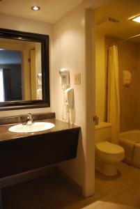 a bathroom with a sink and a toilet and a mirror at Rideau Heights Inn in Ottawa +12 photos