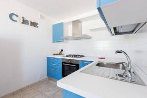 una cocina con armarios azules y fregadero en Casa Sardelli en San Vito dei Normanni