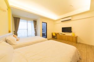 Habitación de hotel con 2 camas y TV de pantalla plana. en Ting Shuan B B&B, en Suao