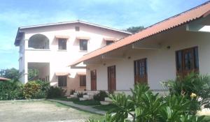 a white house with a red roof at Casa Loma in Pedasí Town