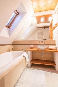 a bathroom with a white tub and a sink at Apartamenty Chata Pod Reglami Zakopane in Zakopane