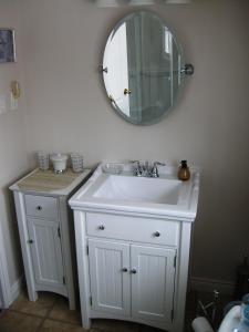 a bathroom with a sink and a mirror on the wall at Tucked Inn the Harbour B&B in Victoria Harbour +53 photos
