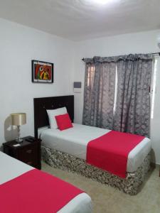 a bedroom with two beds with red and white sheets at Room in Cancun Stadium in Cancún +68 photos