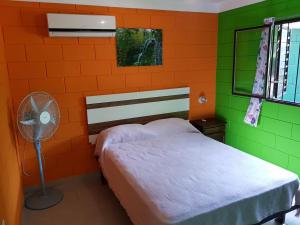 a bedroom with an orange and green wall at Residencia Jose Maria in Santa Rosa de Calamuchita