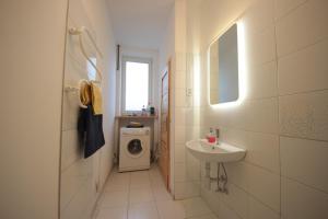 uma casa de banho com um lavatório e uma máquina de lavar roupa em Gallery Apartment em Praga