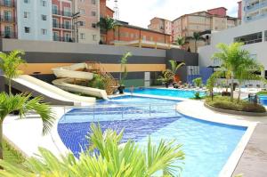 a large swimming pool with a slide in a building at Veredas Rio Quente 110 in Rio Quente