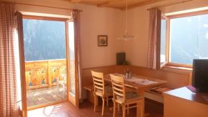 una sala da pranzo con tavolo, sedie e finestra di Plattnerhof a Fundres