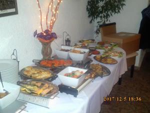uma mesa com muitos tipos diferentes de alimentos sobre ele em Pension Balkan em Eisenhüttenstadt