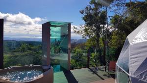 a glass building with a hot tub on a deck at Chira Glamping Monteverde in Monteverde Costa Rica