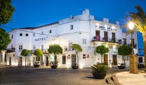 biały budynek z drzewami przed nim w obiekcie Hotel La Casa del Califa w mieście Vejer de la Frontera