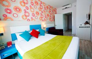 a bedroom with a large white bed with colorful pillows at Ramada Resort Side in Side