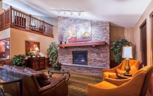 a living room with couches and a fireplace at AmericInn by Wyndham Monmouth in Monmouth