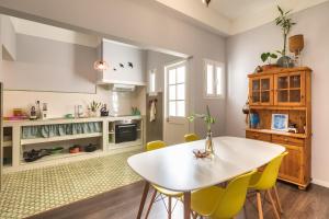 フンシャルにあるEndemic - Concept Apartmentのキッチン(白いテーブル、黄色い椅子付)